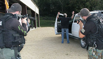 The officer with a rifle works in tandem with the one with a shotgun during this felony car stop drill.